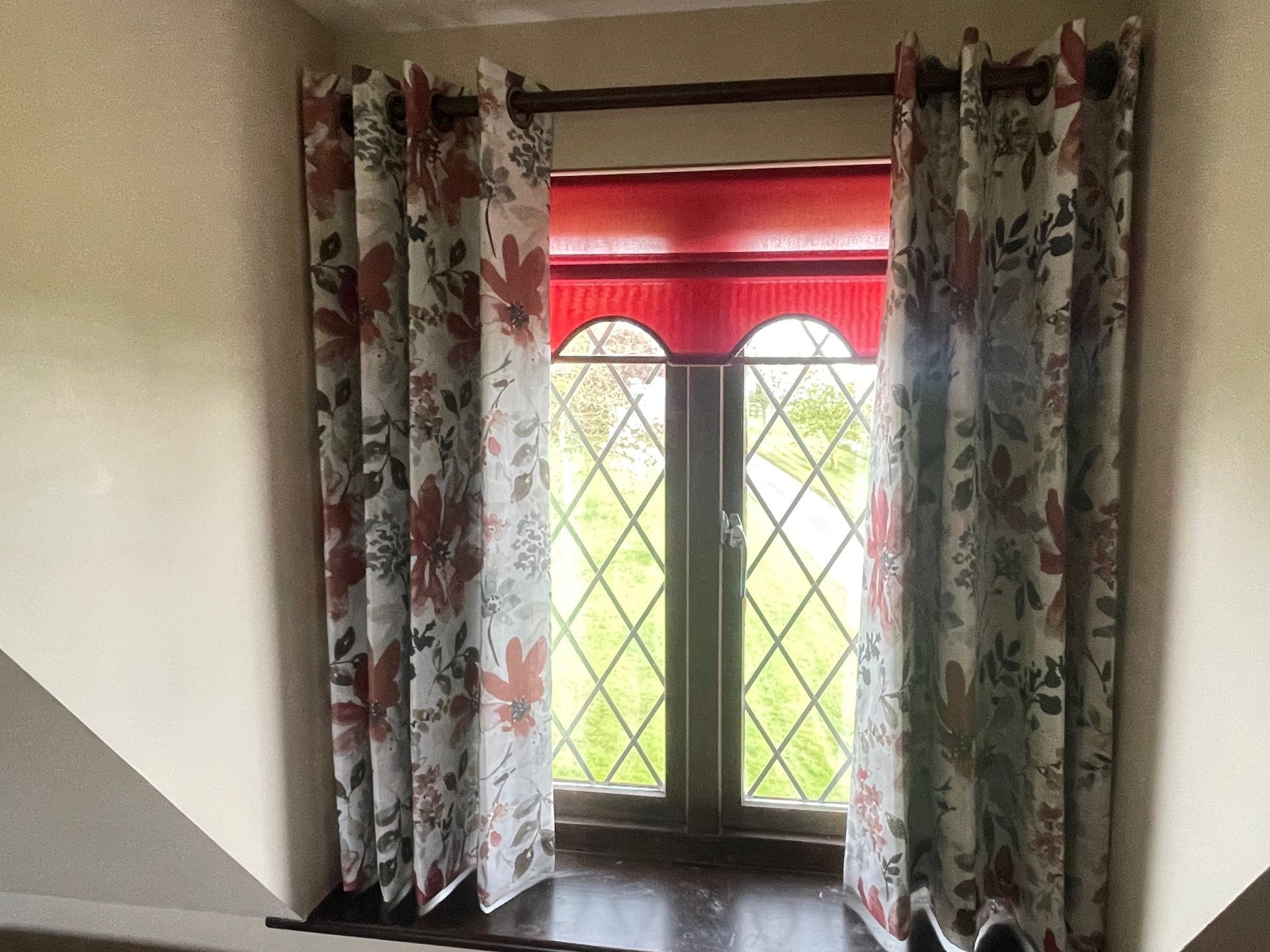 Eyelet curtains on a wooden pole for a small window