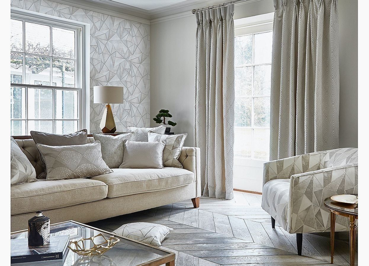 A living room with a couch , chair , coffee table and curtains.