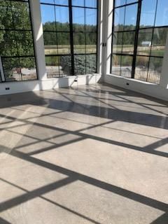 A large room with a lot of windows and a concrete floor.