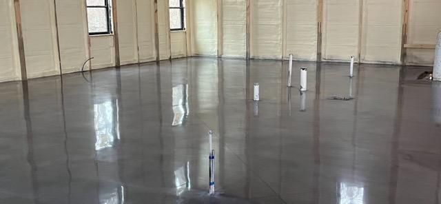 A large room with a shiny concrete floor and walls.