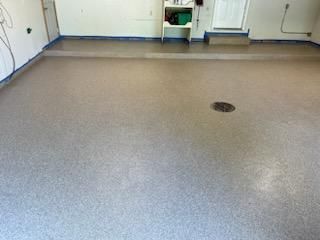 A garage floor with a drain in the middle of it.