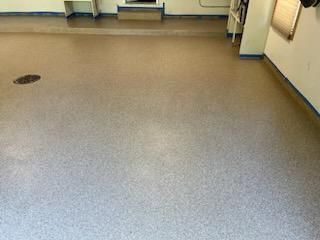 A room with a concrete floor and a white wall.