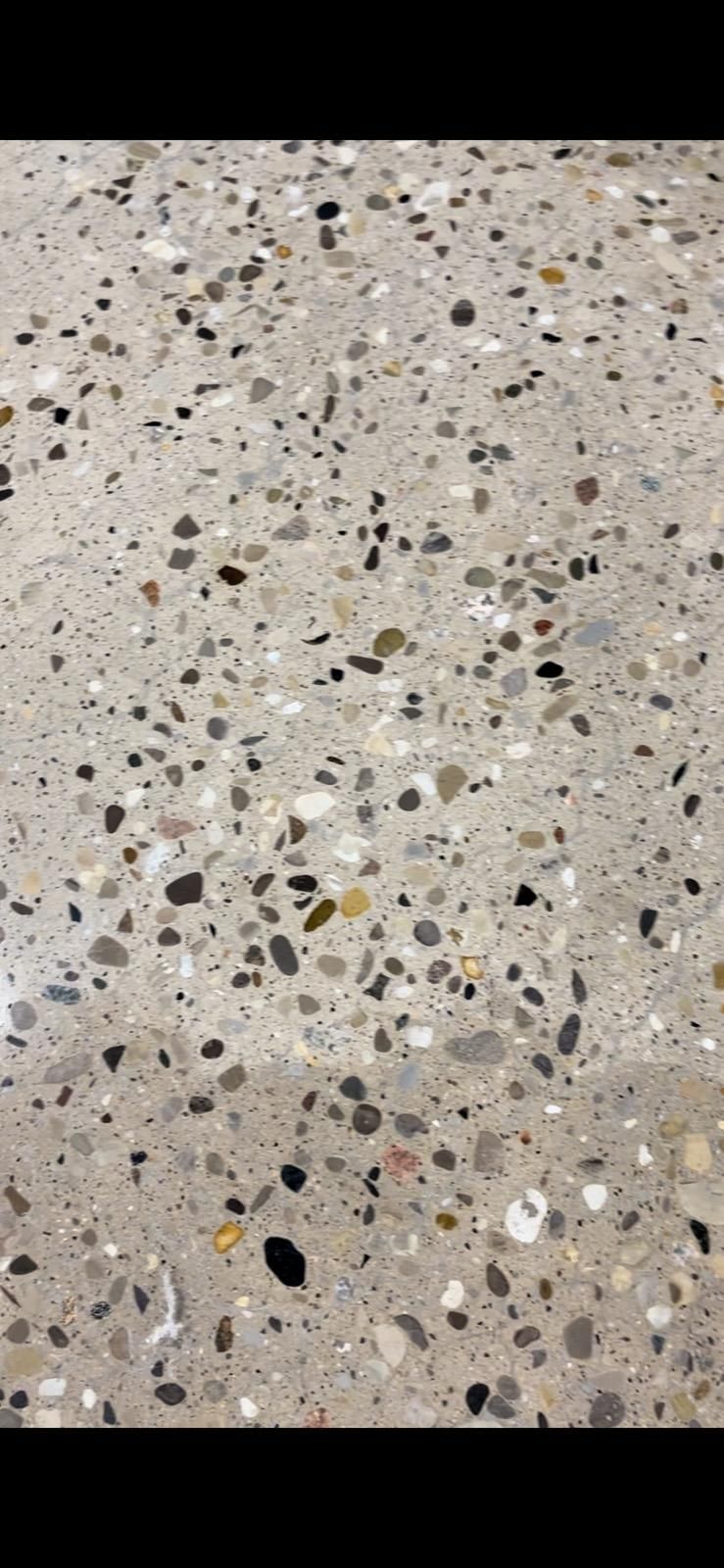 A close up of a concrete floor with a lot of small rocks on it.