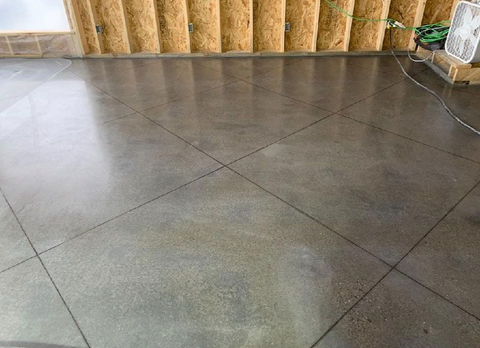 A concrete floor with a wooden wall in the background.