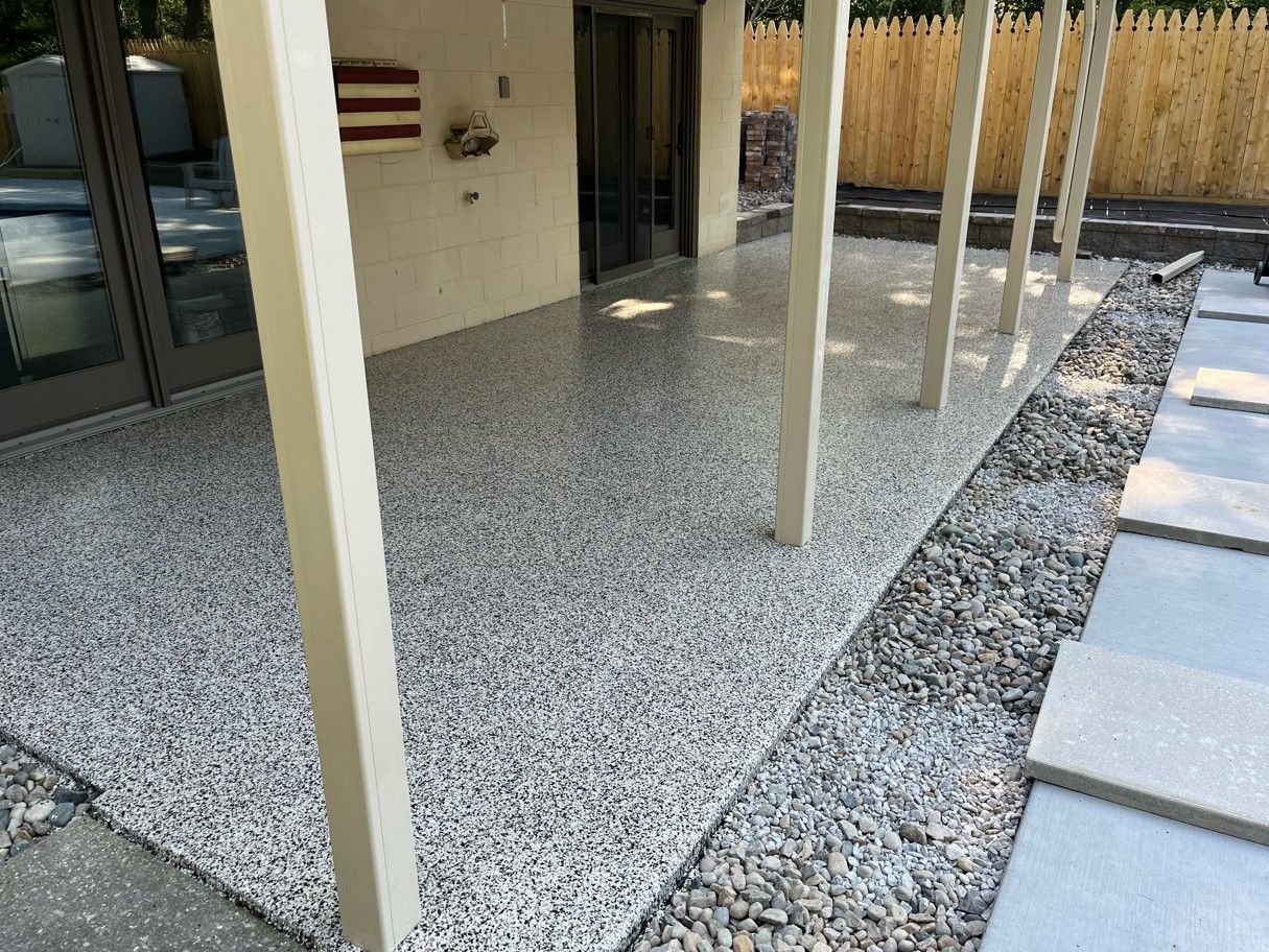 A patio with a covered area and a flag on the wall.