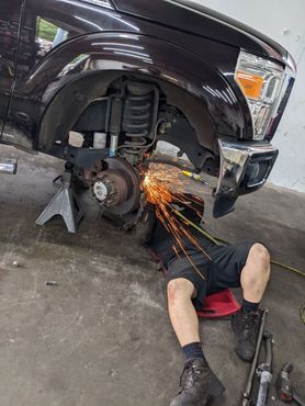 Mechanic Grinding Metal On Vehicle Undercarriage | Full-Service Auto Repair