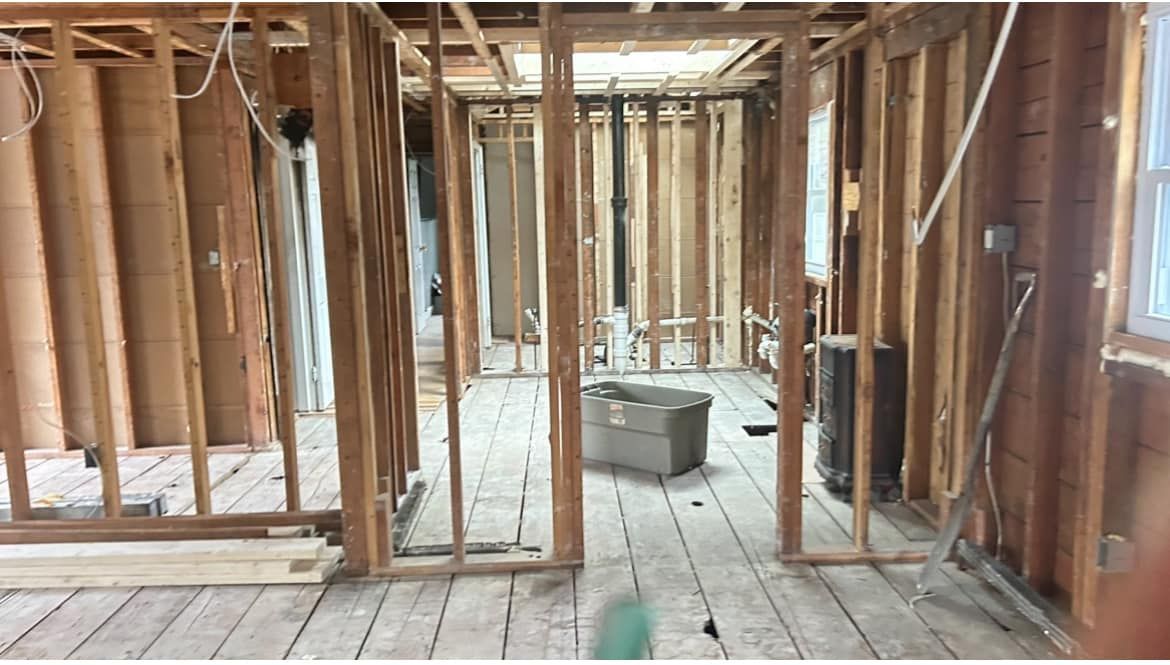 A room with wooden walls and a wooden floor under construction.