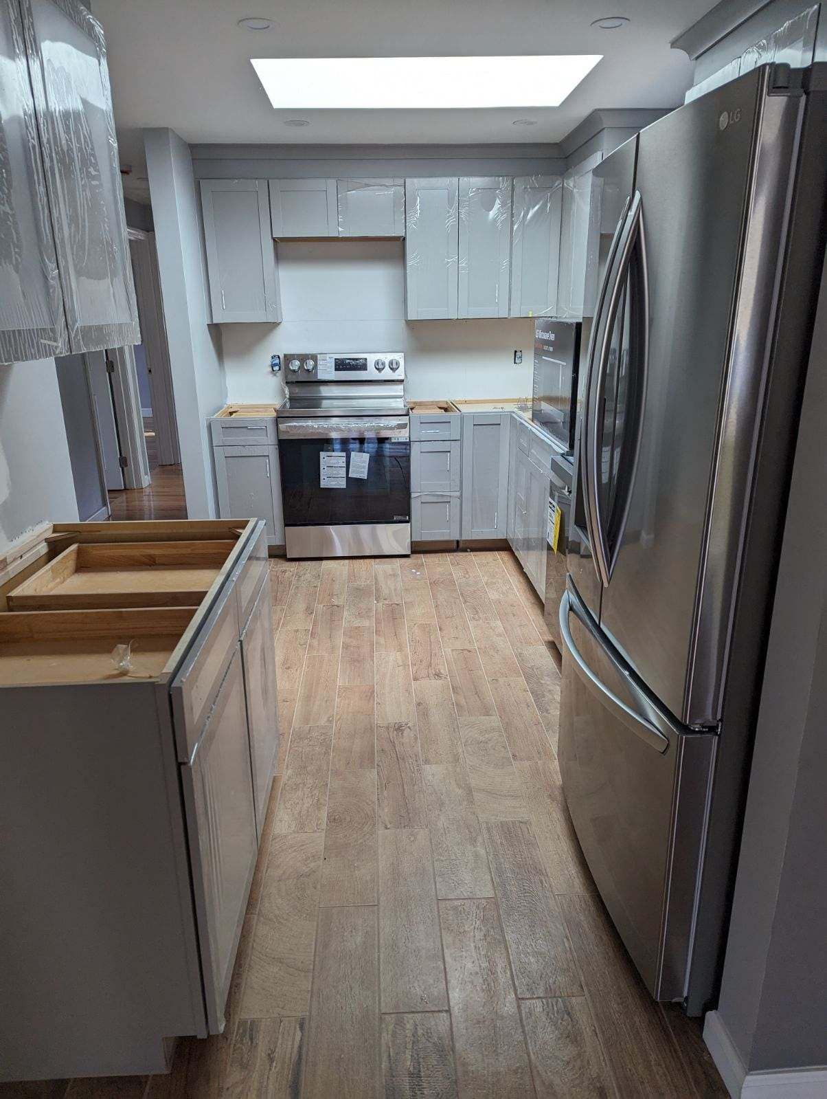 A kitchen with stainless steel appliances and white cabinets.