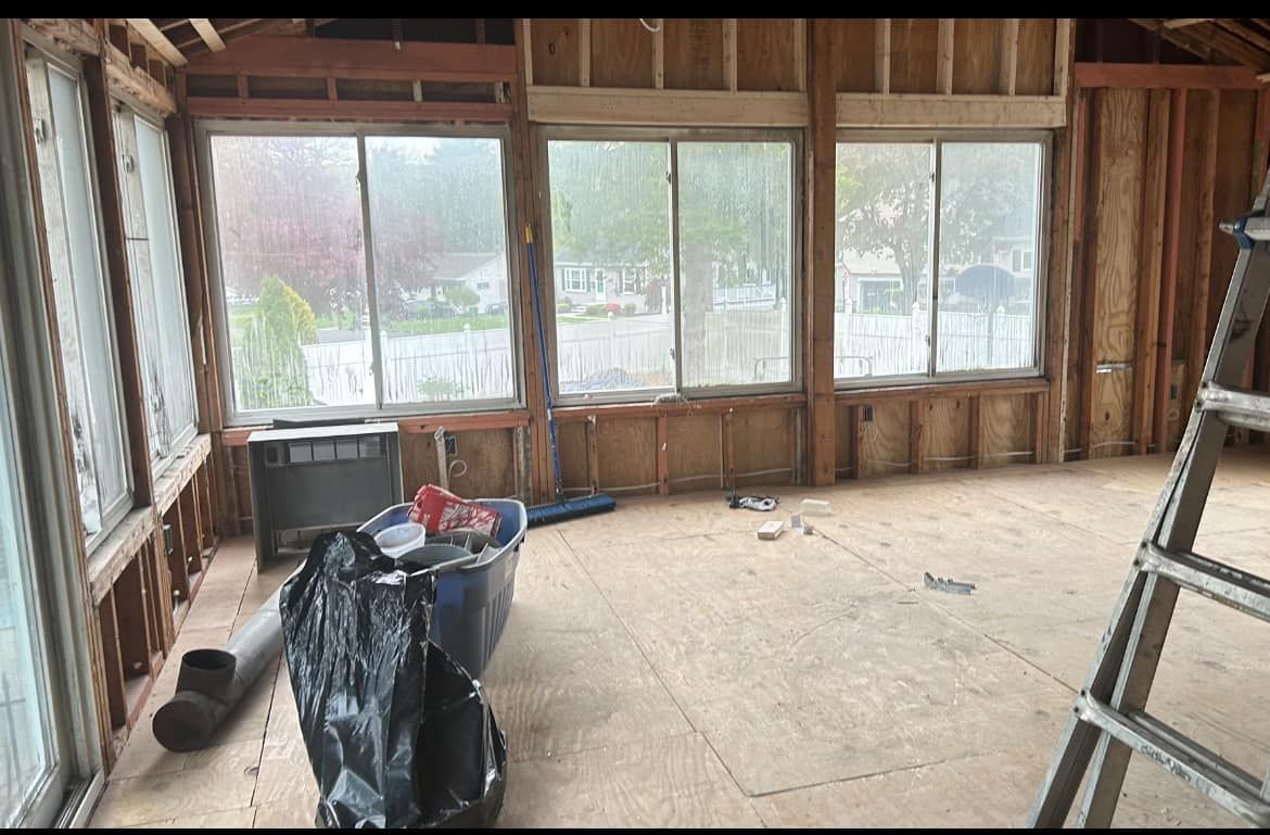 A room with a lot of windows and a ladder in it