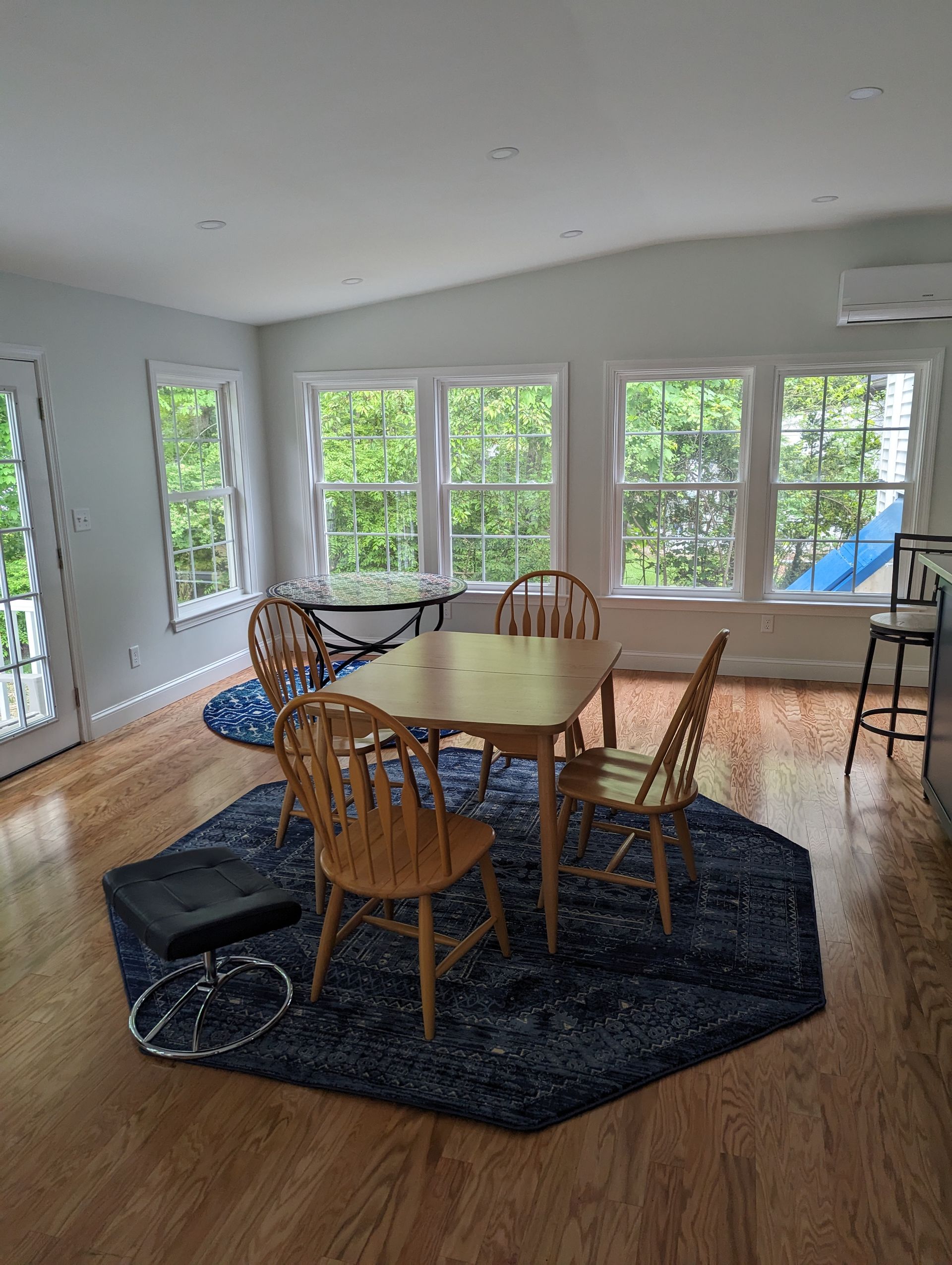 There is a table and chairs in the middle of the room.