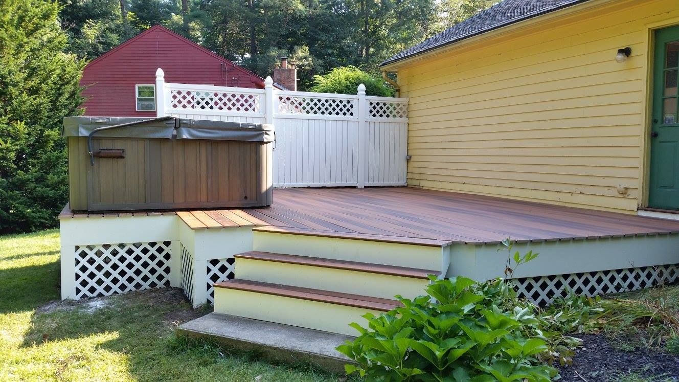 A white deck with a white railing in front of a white house
