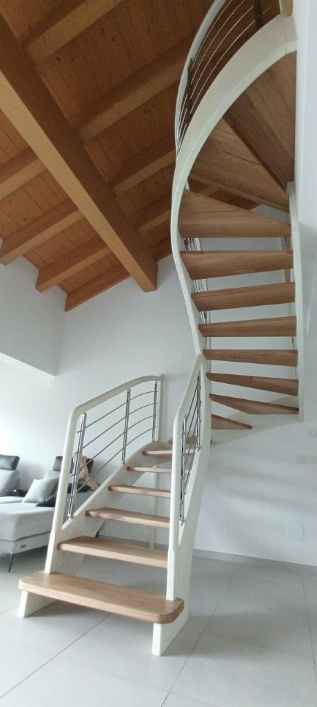 Una scala a chiocciola con gradini in legno e ringhiera bianca