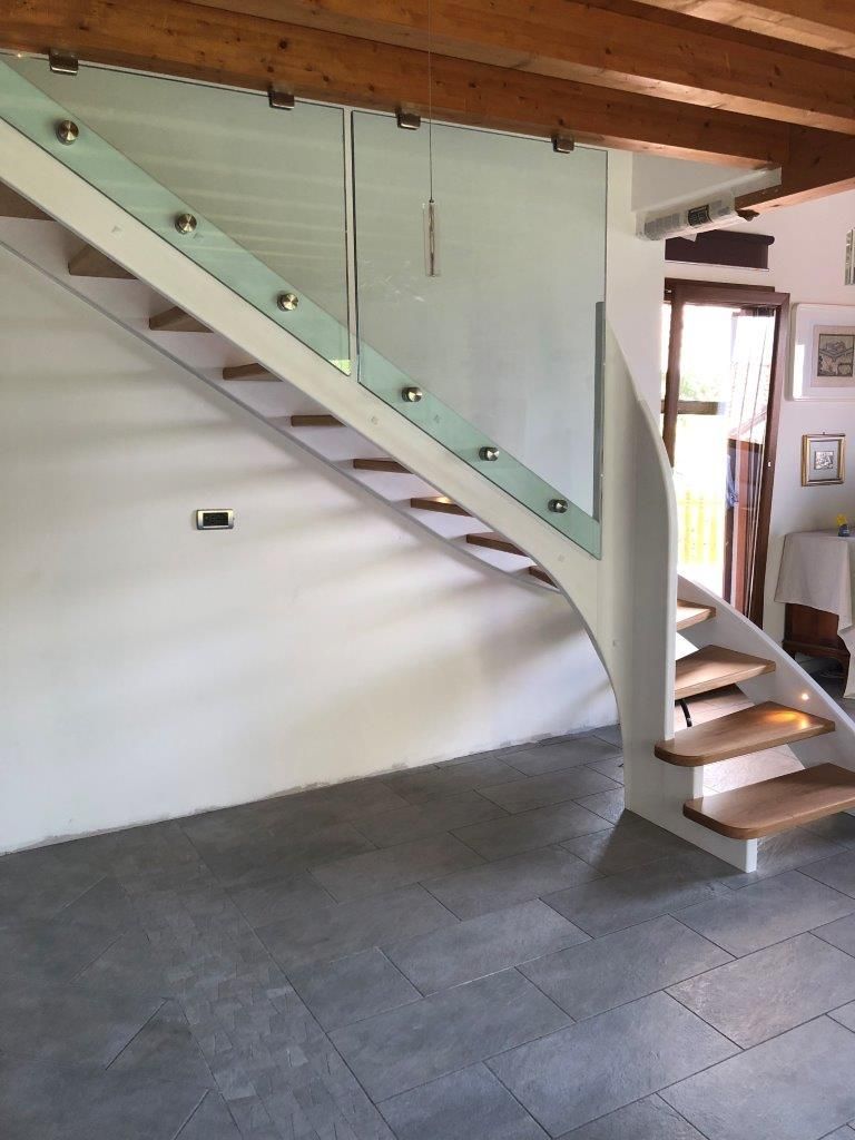 Una scala con gradini in legno e ringhiera in vetro