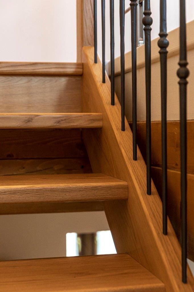 Primo piano di una scala in legno con ringhiera in metallo.