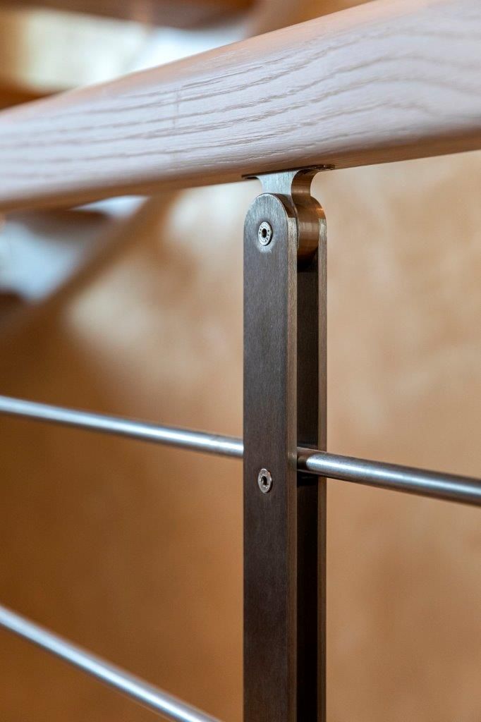 Un primo piano di una ringhiera metallica con un corrimano in legno