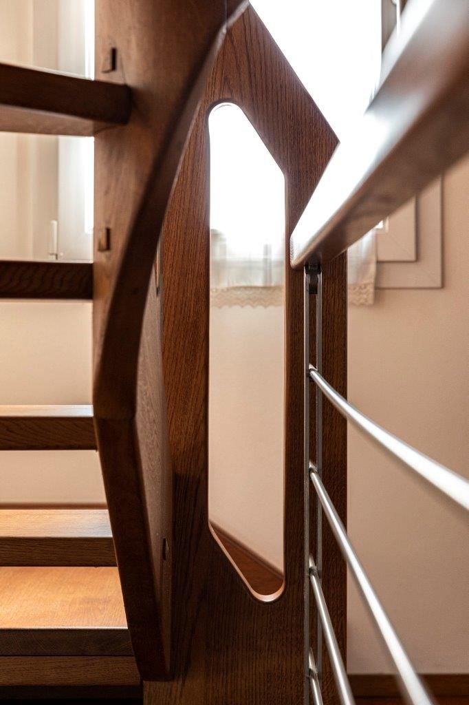 Un primo piano di una scala in legno con ringhiera in metallo