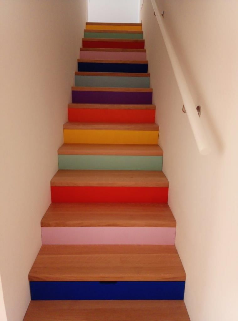 Una serie di scale colorate con una ringhiera bianca