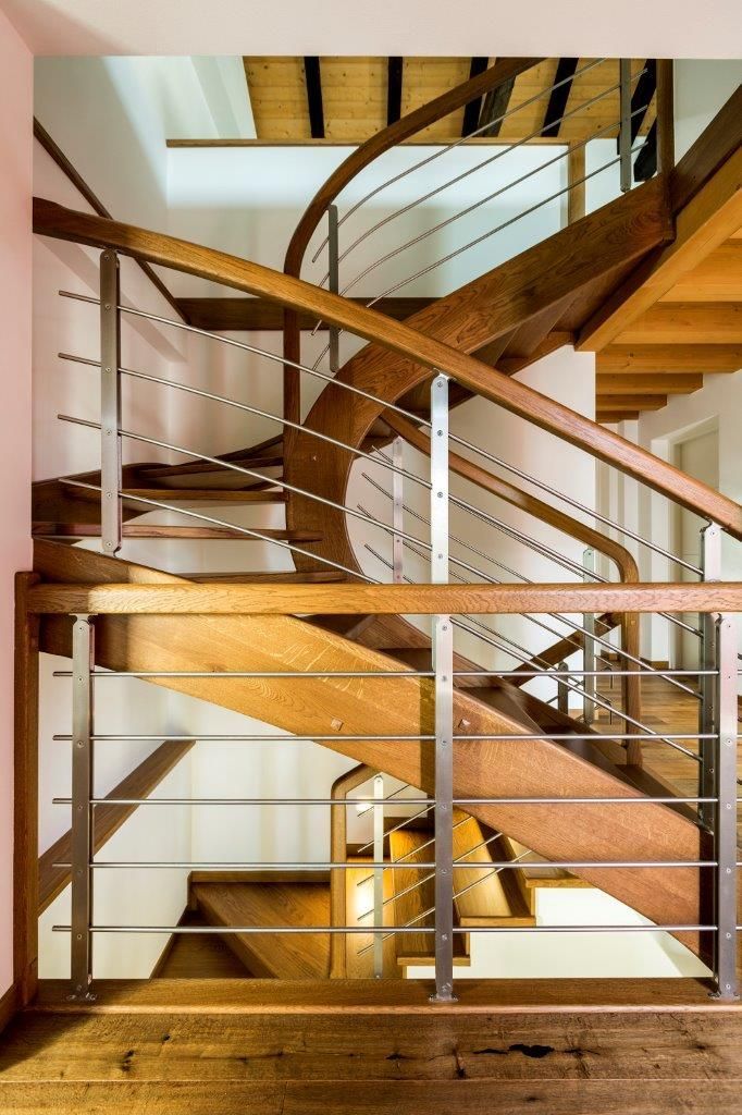 Una scala in legno con ringhiera in acciaio inox