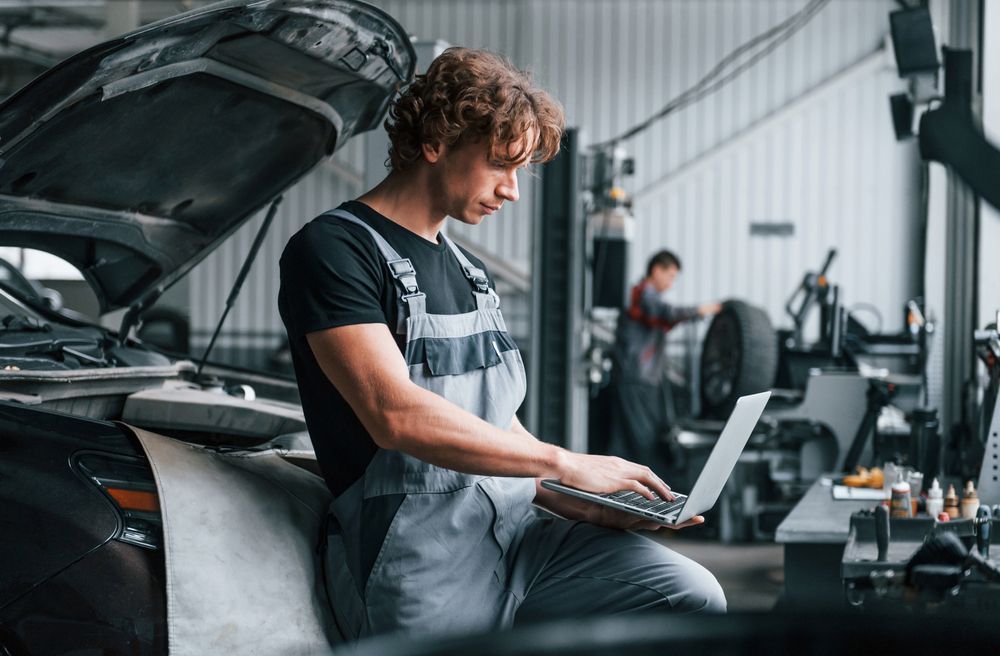 Adult man in grey colored uniform works in the automobile salon - Mechanic in Belconnen, ACT