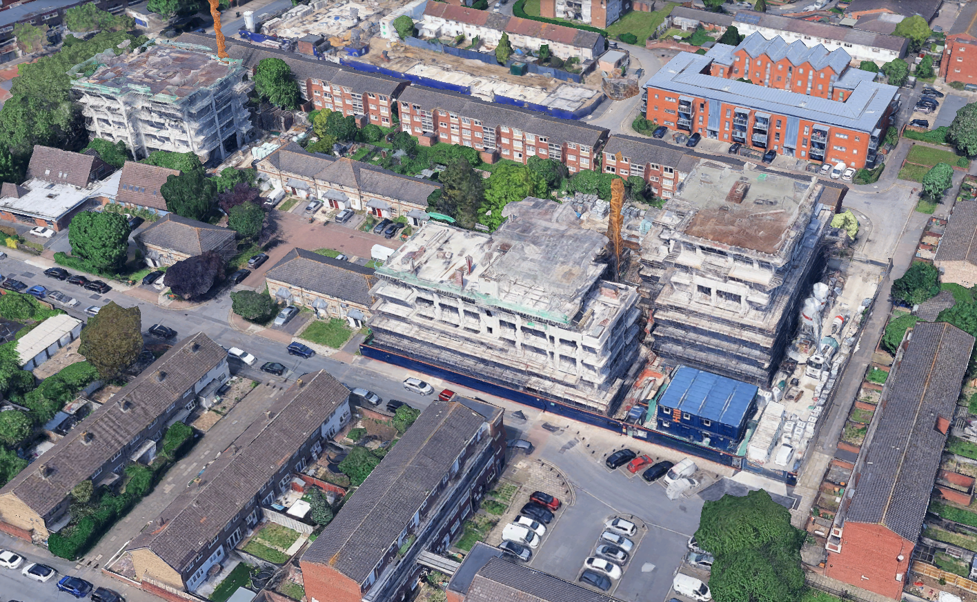 Aerial view of a residential neighborhood with several multi-story apartment buildings under construction.