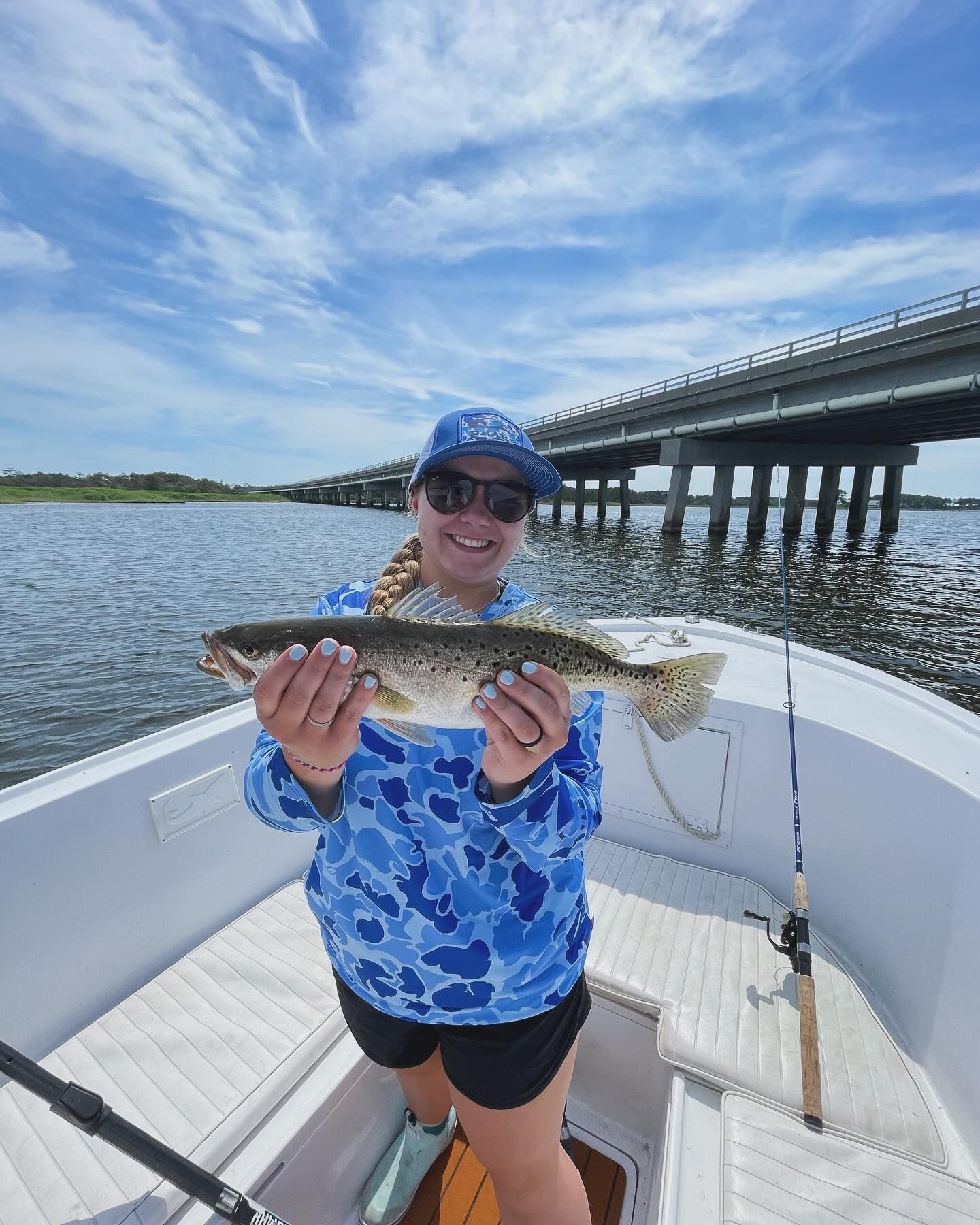 A woman is holding a fish in her hands on a boat.