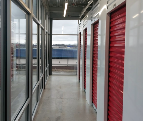 A hallway with a lot of windows and red doors