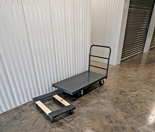 A cart with wheels is sitting on a concrete floor in a room.