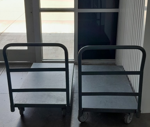 Two carts are sitting next to each other in front of a door.