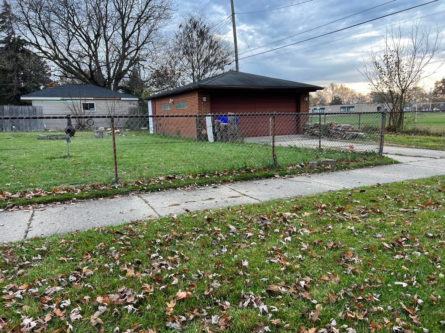a chain link fence surrounds a brick garage.