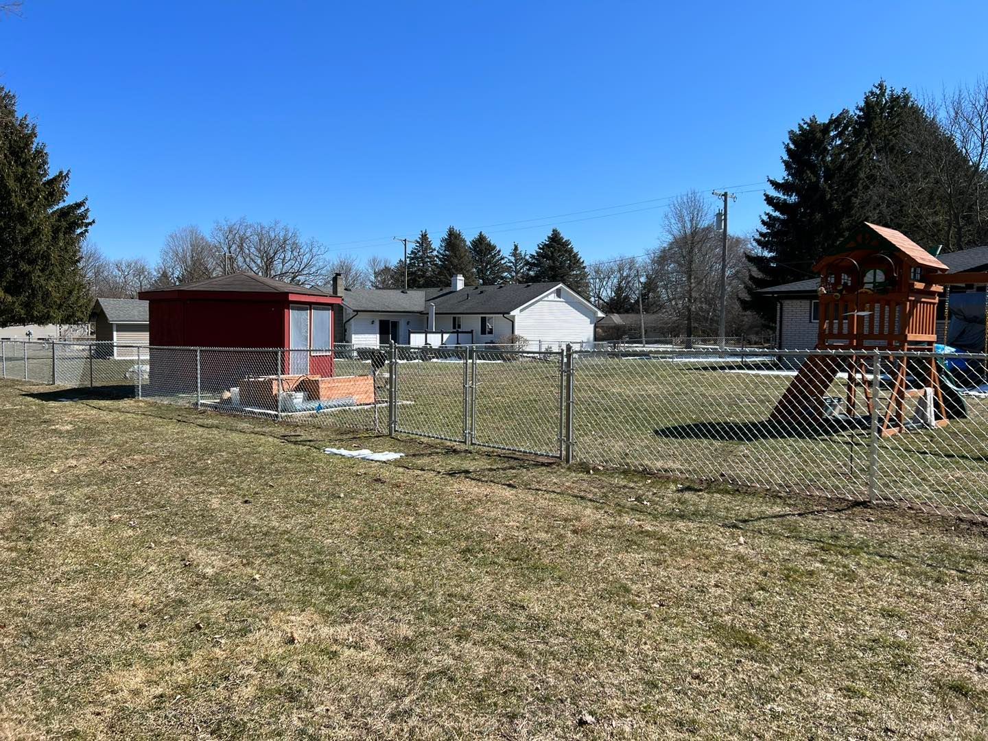 a backyard with a chain link fence and a playground.
