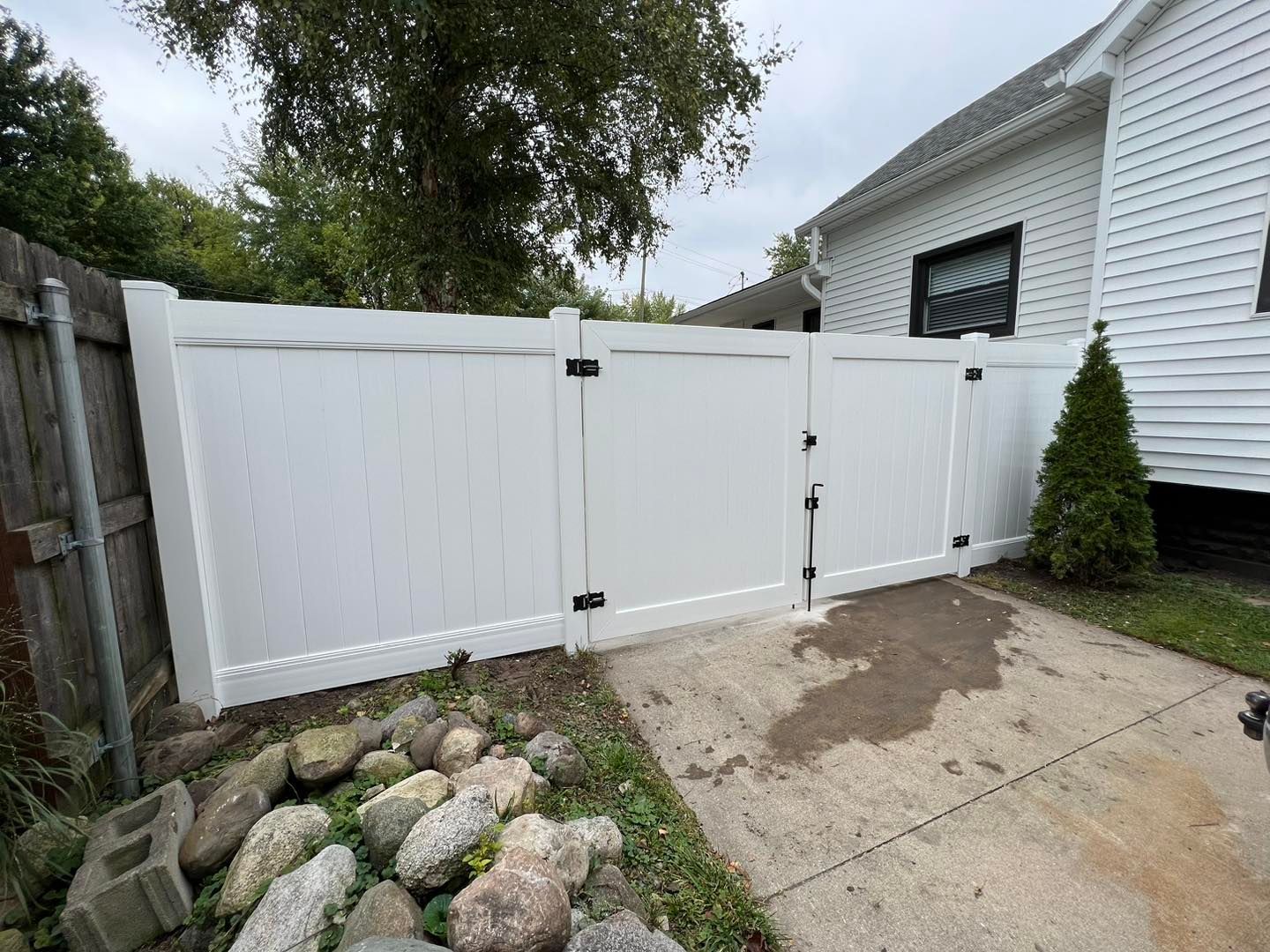 a white fence with a gate in front of a white house.