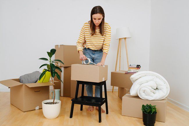 Woman Sealing Cardboard Boxes — Mobile, AL — Azalea City Moving Co.