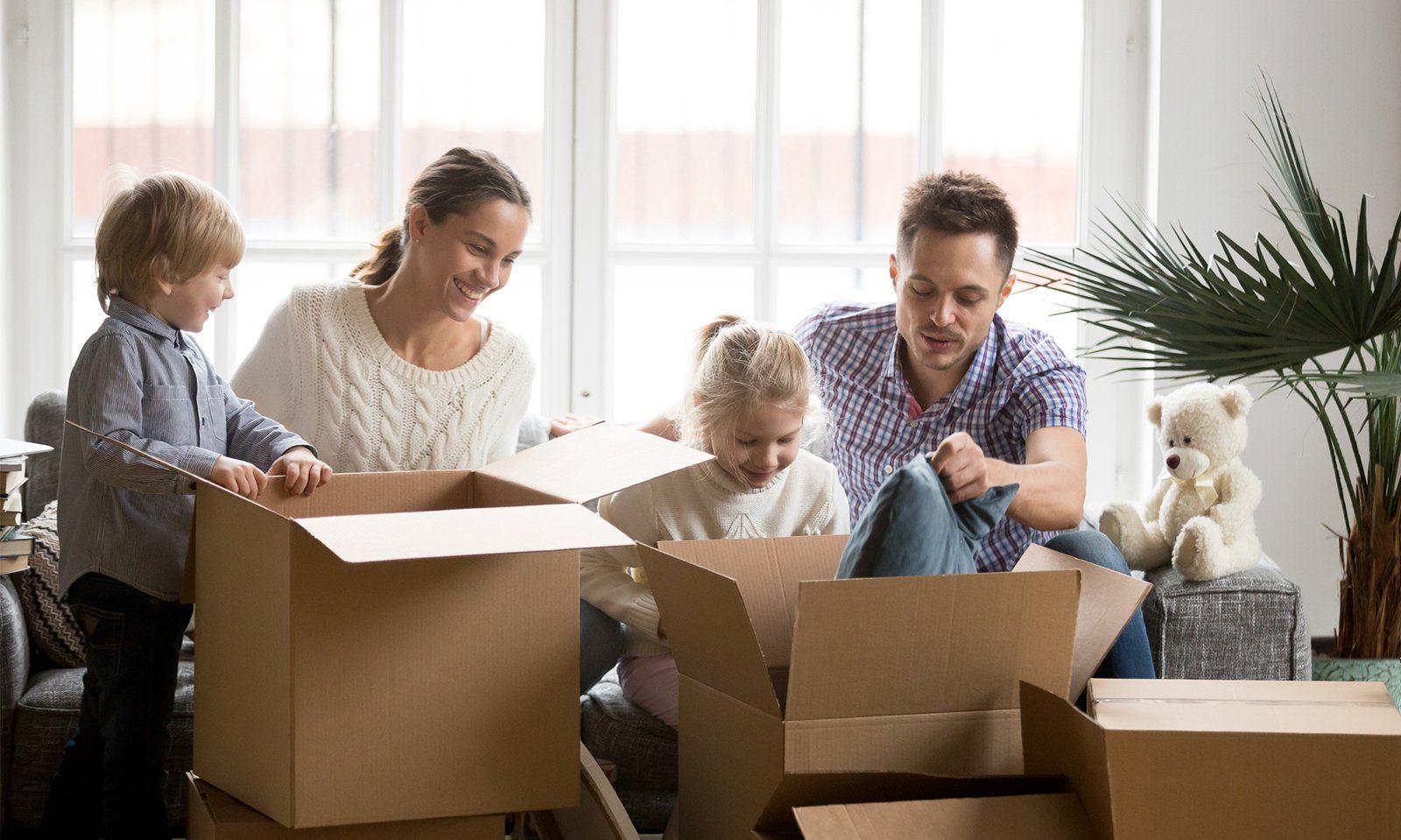 Happy Family With Children Packing Boxes — Mobile, AL — Azalea City Moving Co.