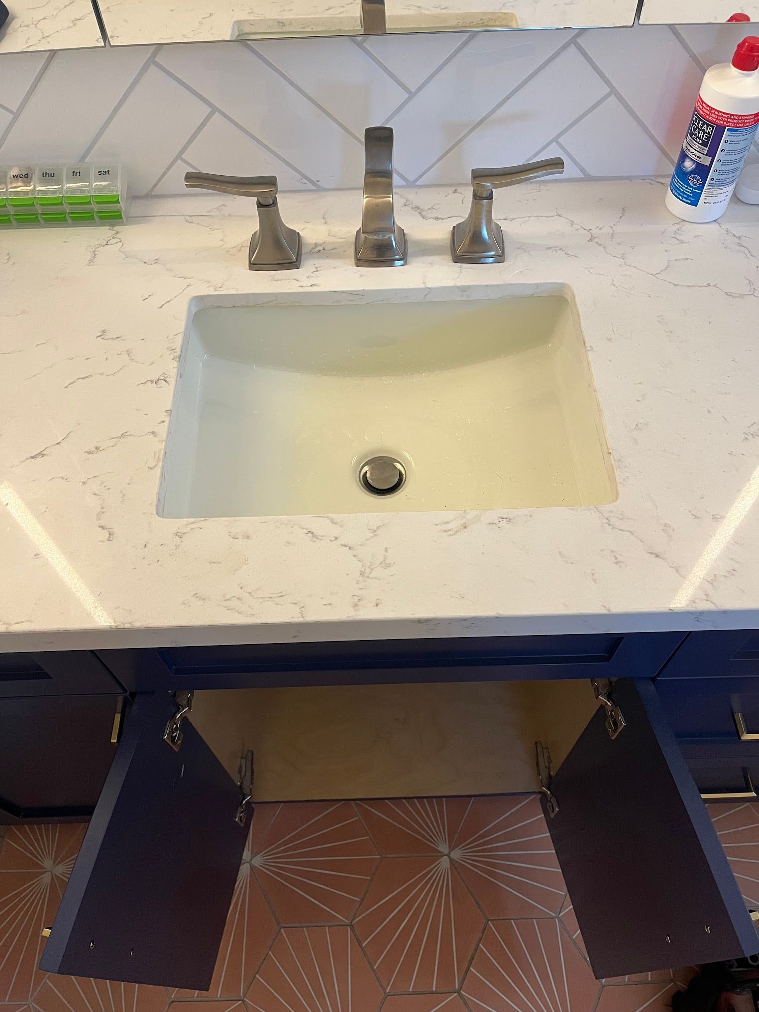 Bathroom vanity with open blue cabinets, white countertop, and sink.
