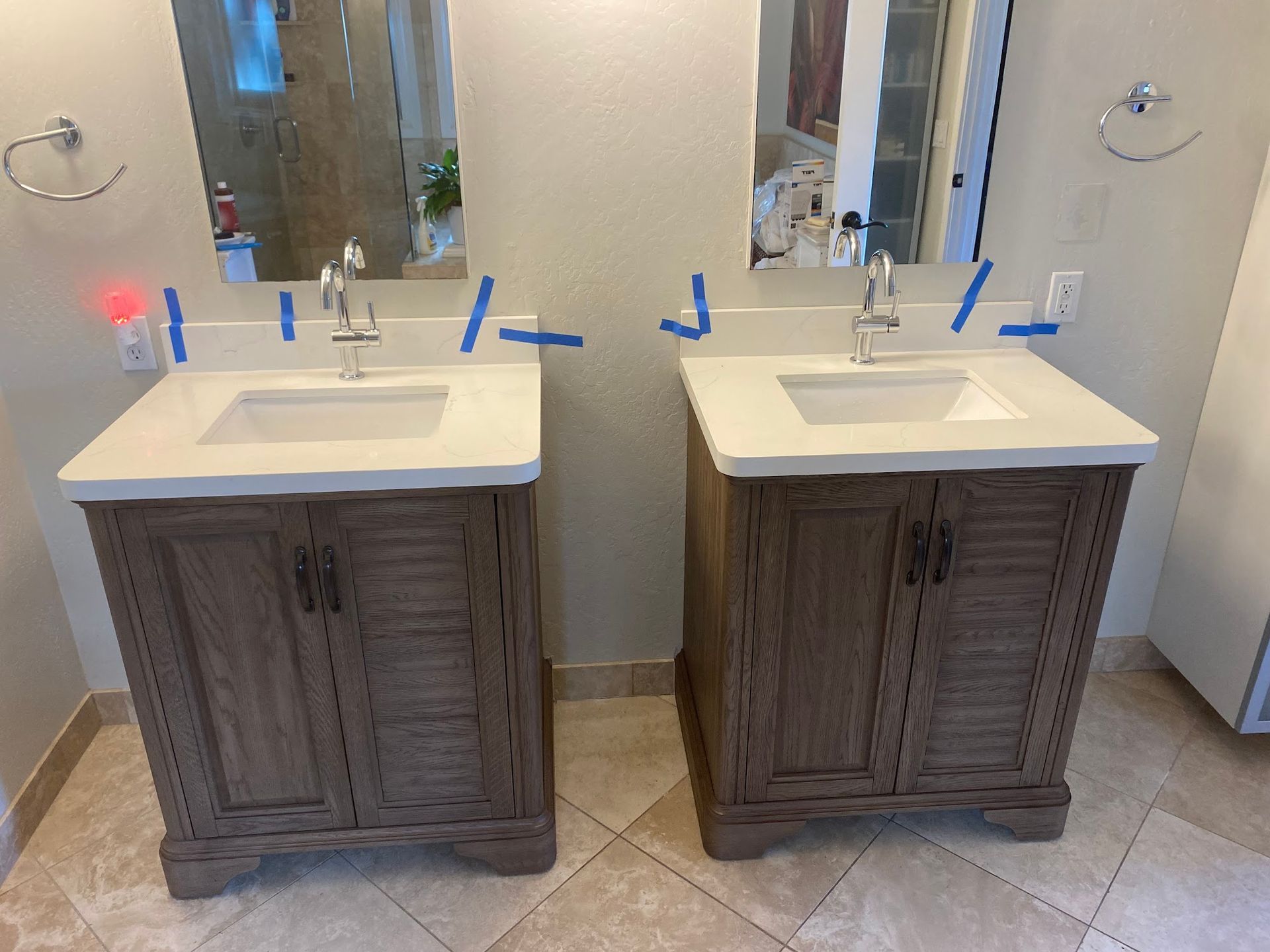 Two wood bathroom vanities with sinks and mirrors.