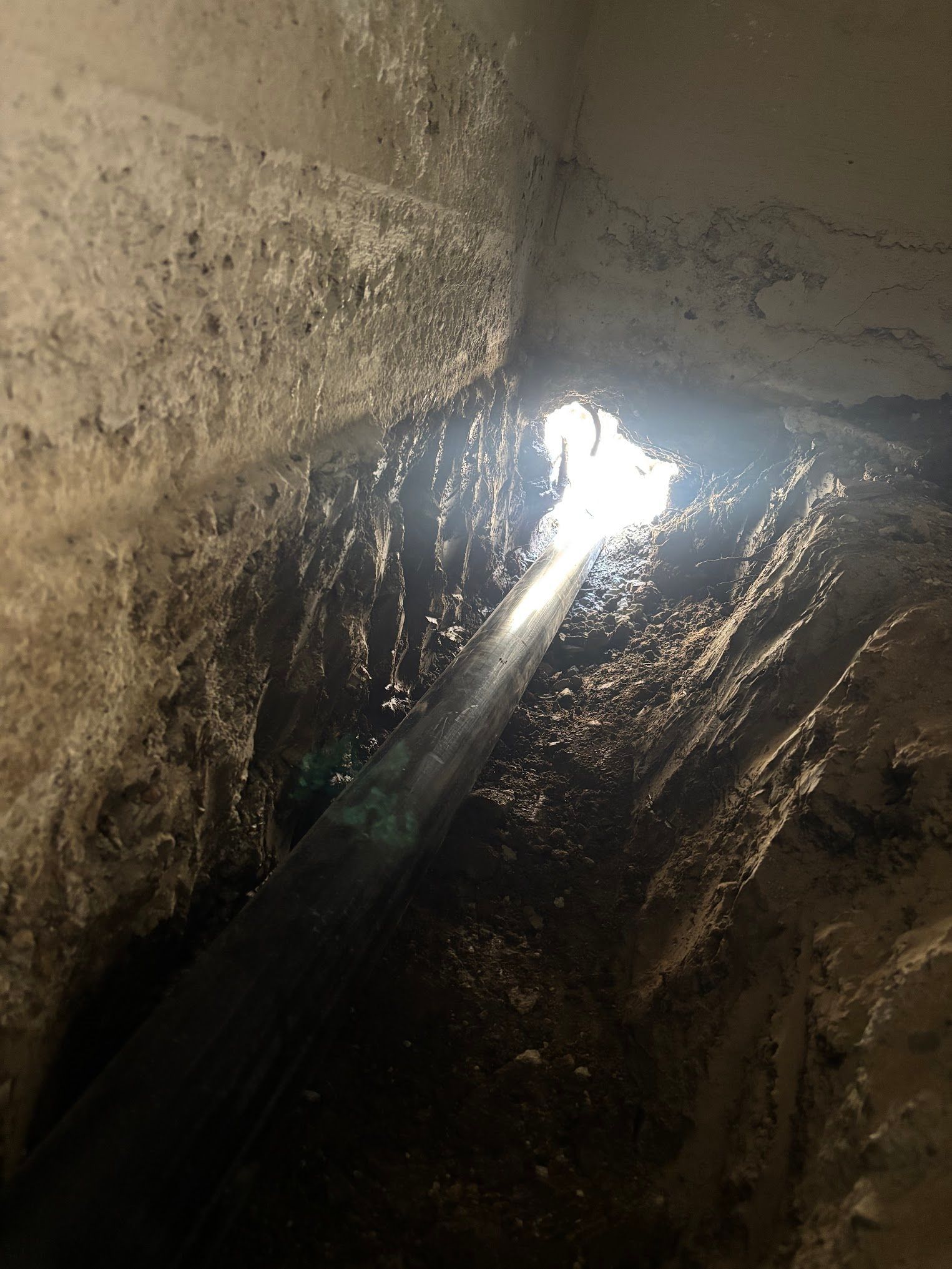Dark, wet cavern interior; light streams through a hole in the ceiling.