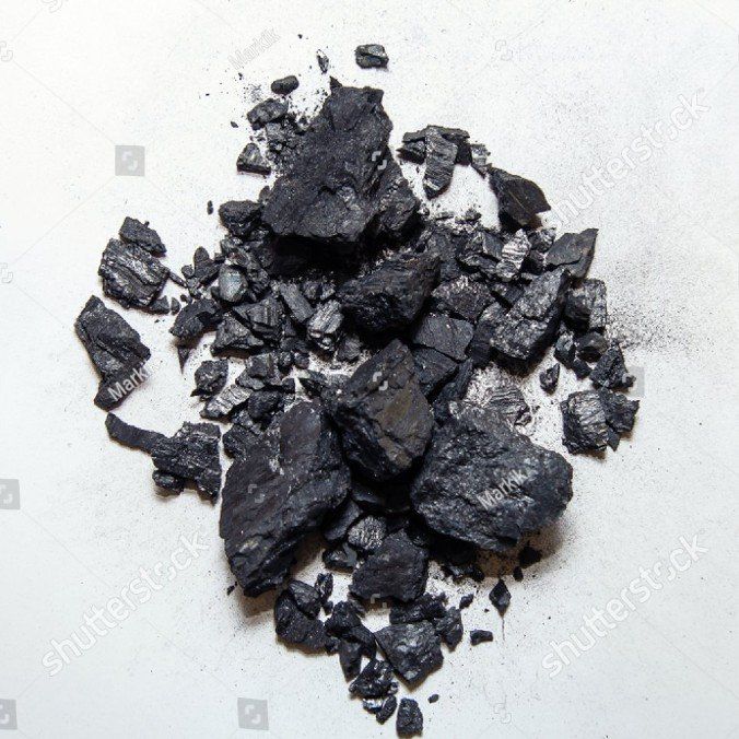 Ein Haufen schwarzer Steine ​​auf einer weißen Oberfläche.