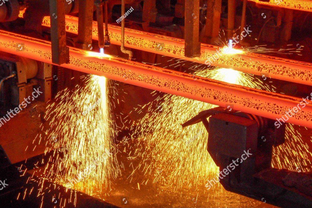 In einer Fabrik schneidet eine Maschine ein Stück Metall.