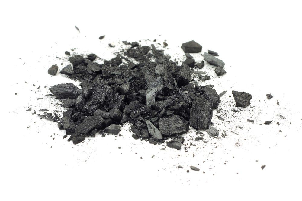 Ein Haufen schwarzer Kohle auf weißem Hintergrund.