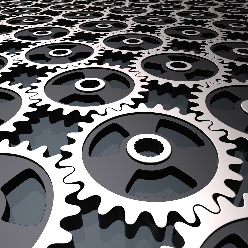 Eine Reihe schwarzer und silberner Zahnräder mit einem weißen Kreis in der Mitte