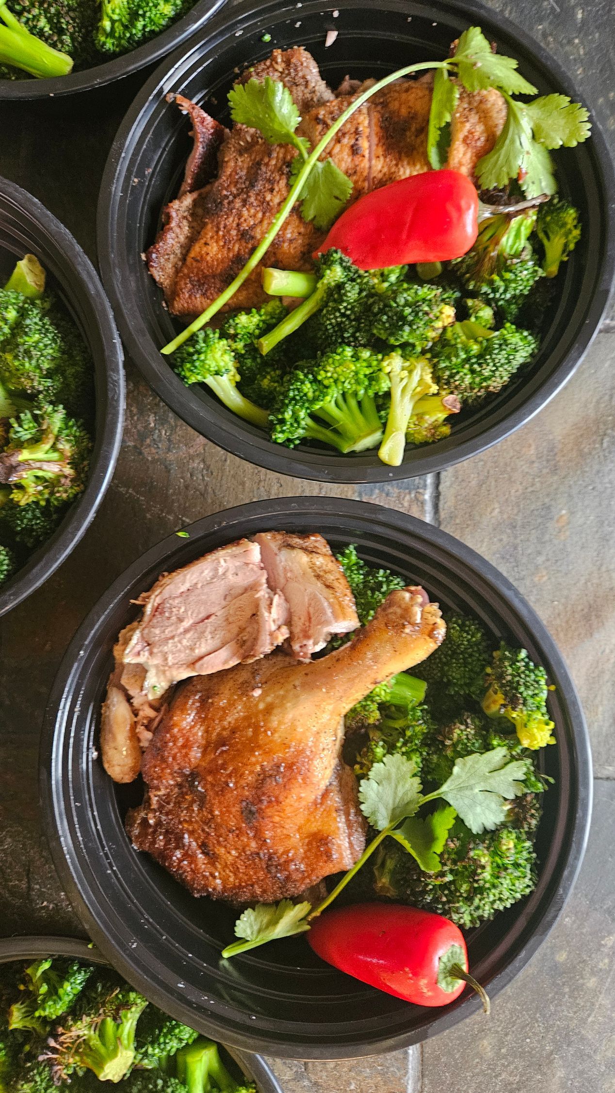 A close up of a bowl of broccoli and meat on a table.