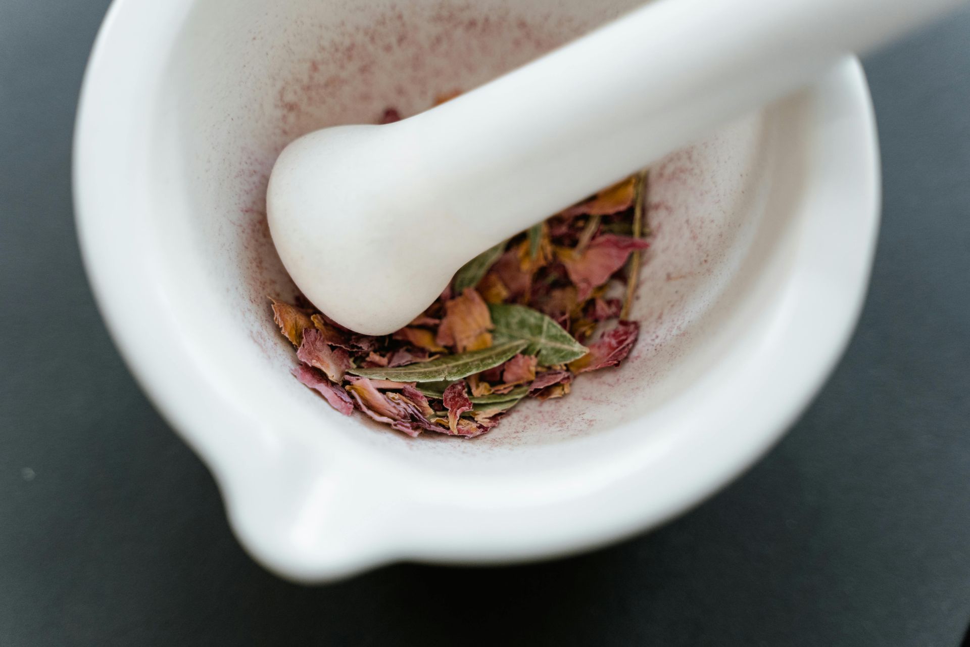 A mortar and pestle with dried flowers in it.