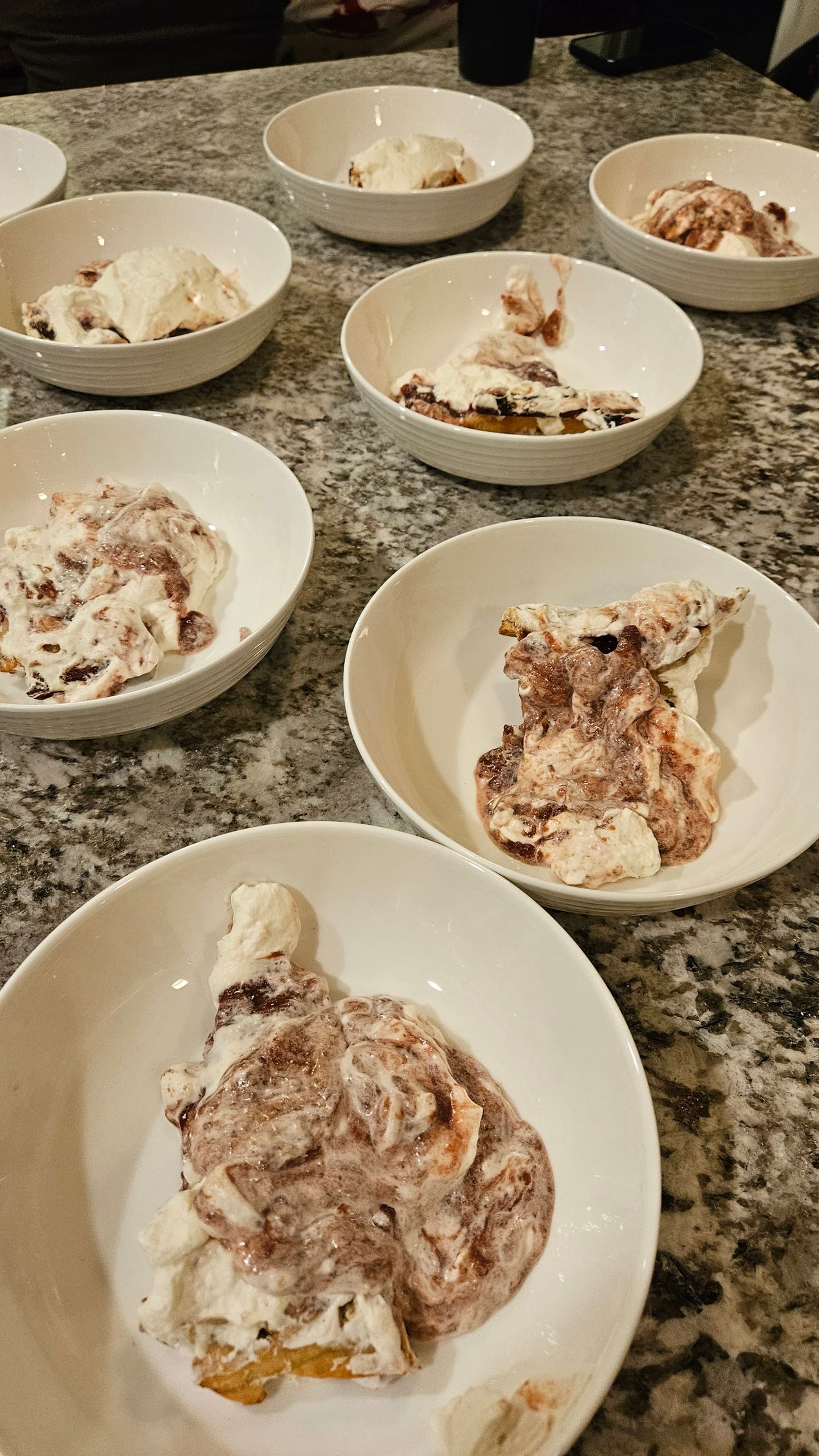A table topped with plates of food and a glass of wine.