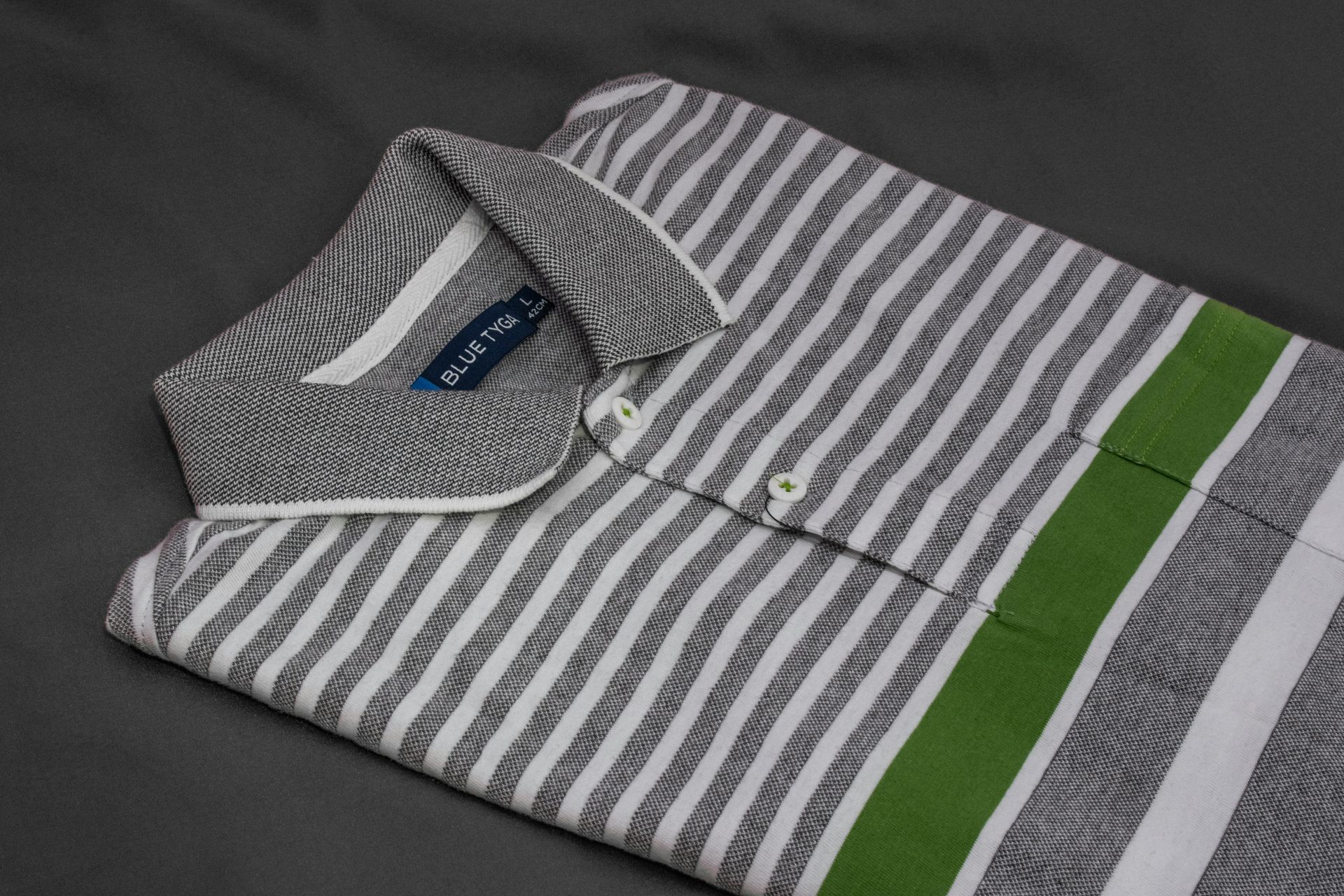 A grey and white striped polo shirt with a green stripe