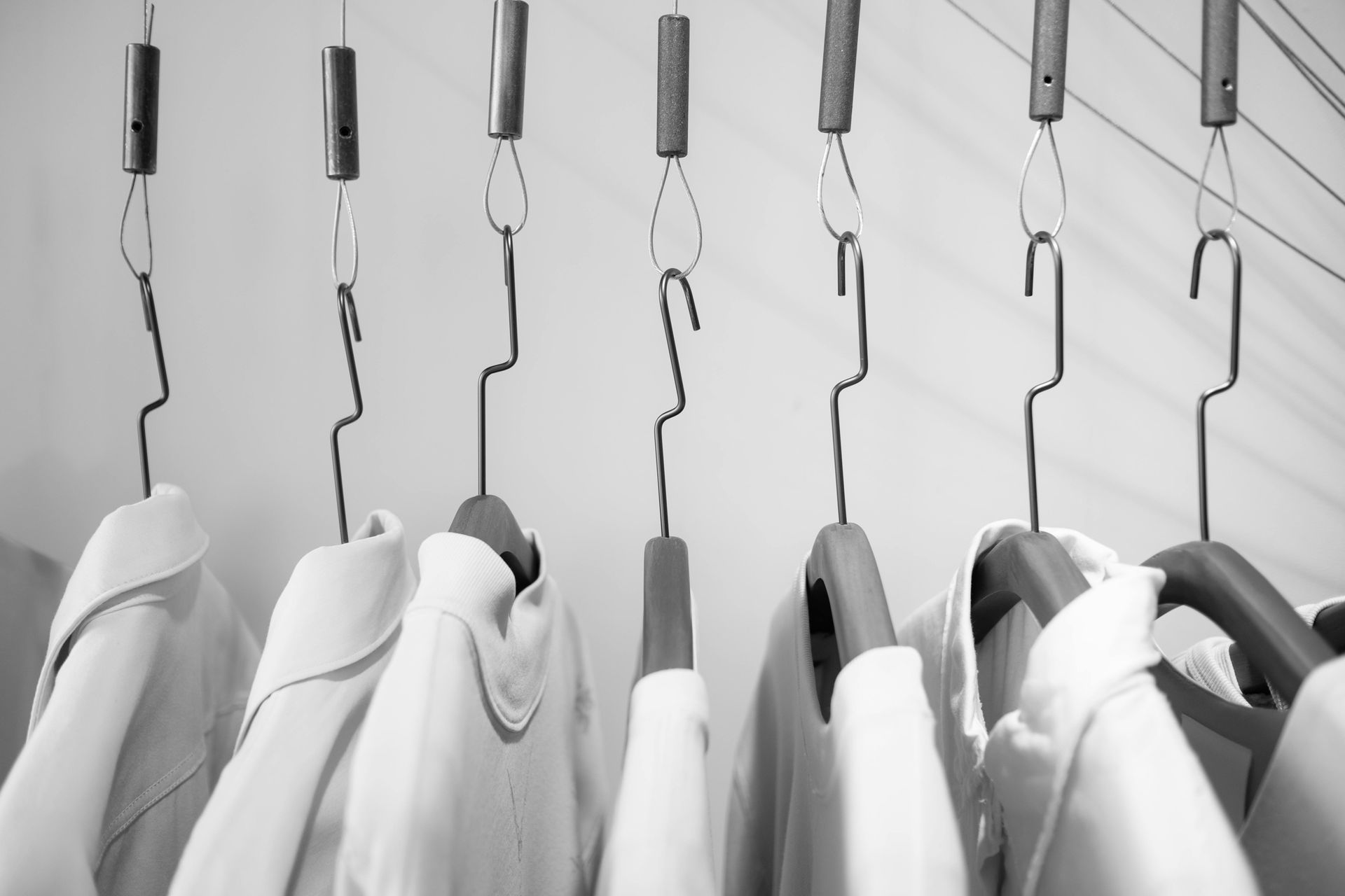 A black and white photo of clothes hanging on a rack