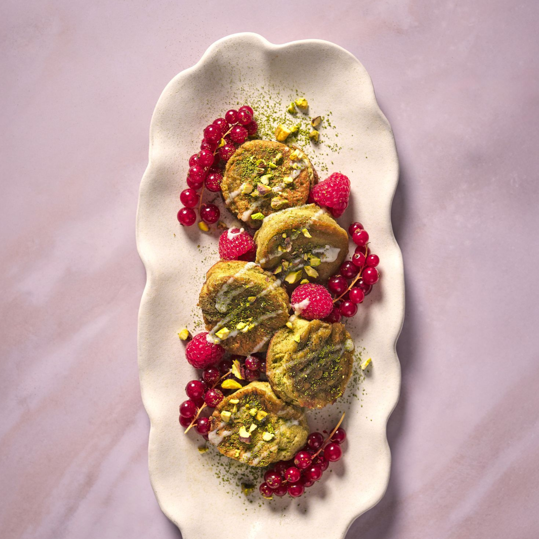 Three plates of food are sitting on a wooden table next to a glass of beer.