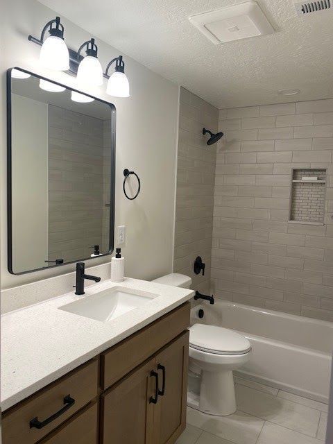 Modern bathroom with a white countertop, wood vanity, and a tiled shower area.