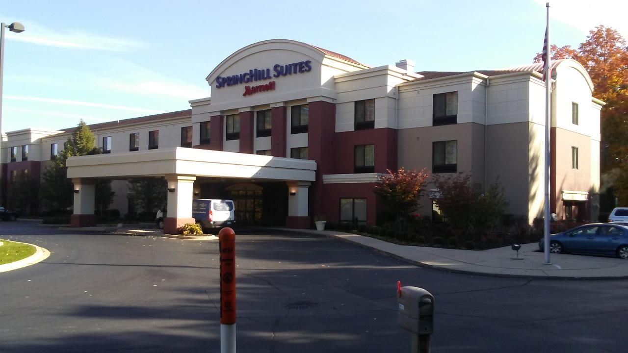 Springhill Suites by Marriott hotel with a red and white exterior on a sunny day.