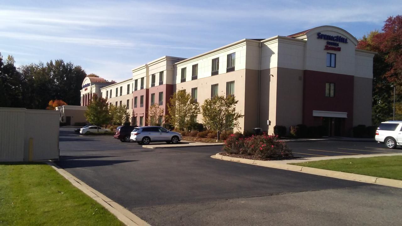 SpringHill Suites hotel with cars parked outside on a sunny day.