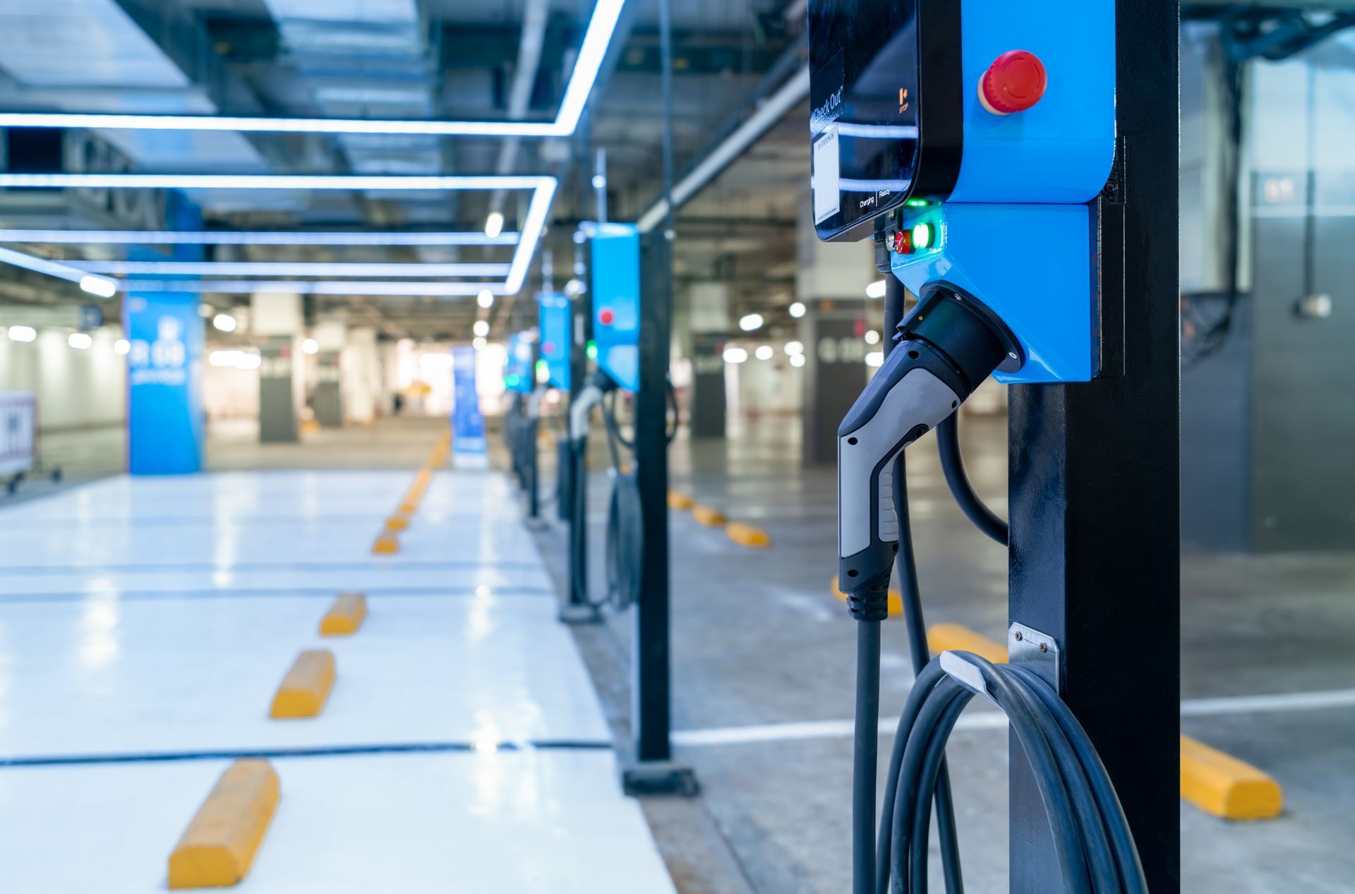 An electric car is being charged at a charging station in a parking garage.